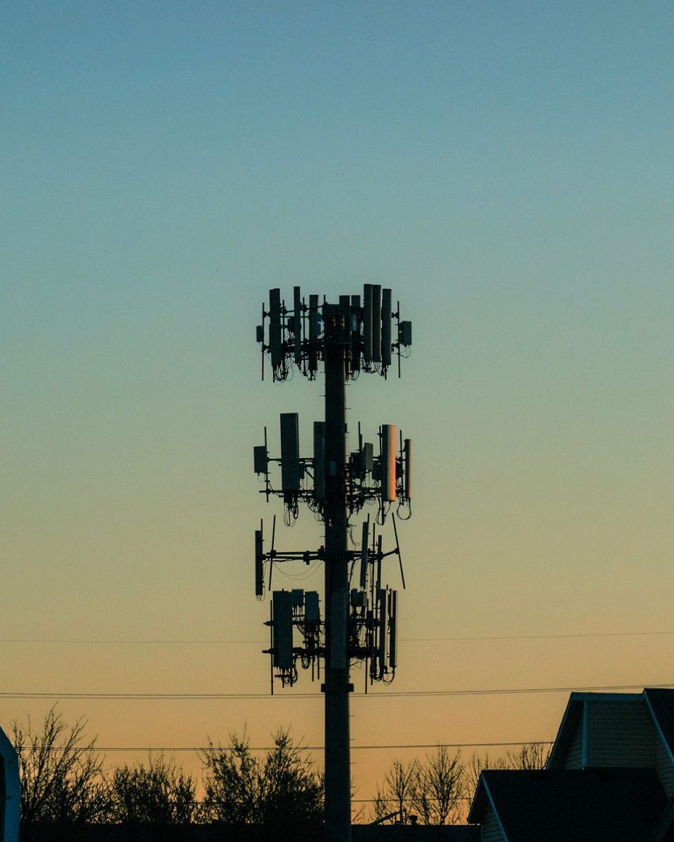 A cell tower silhouetted against a blue-to-amber dusk sky, edited with Fujifilm Profiles