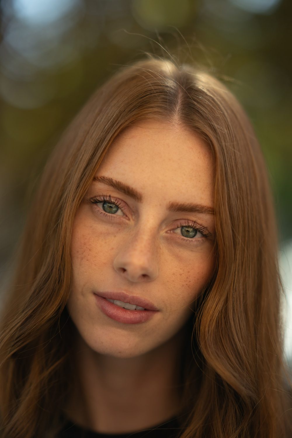 A woman with red hair and freckles, unedited