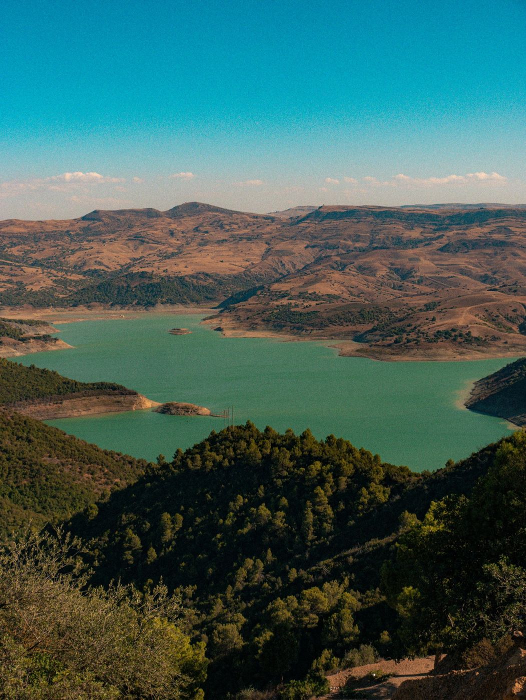 A lake winding through green hills