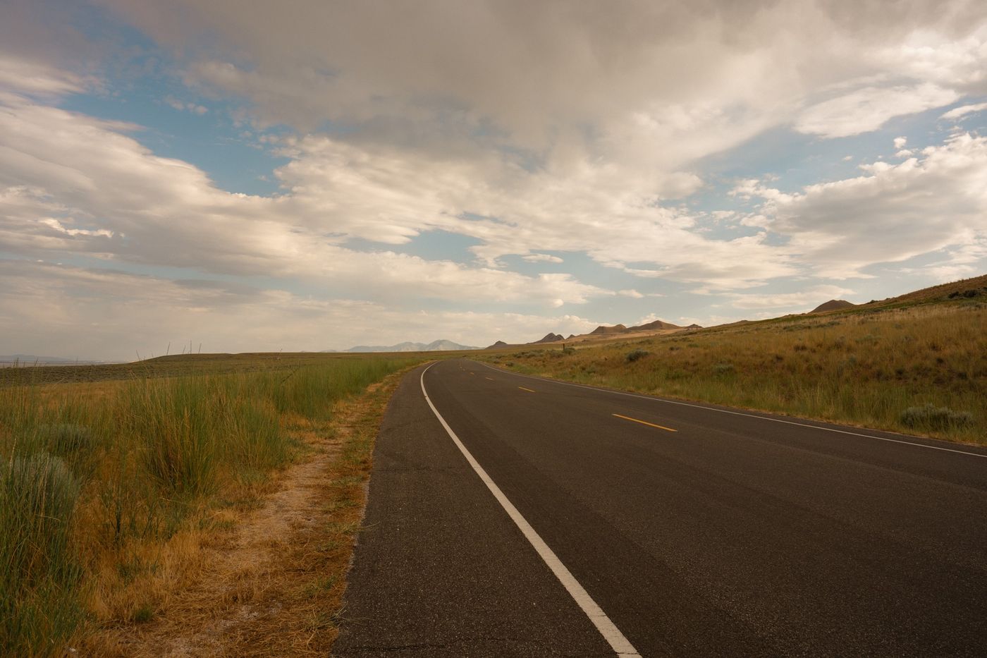 A road under big clouds, edited with Domingo
